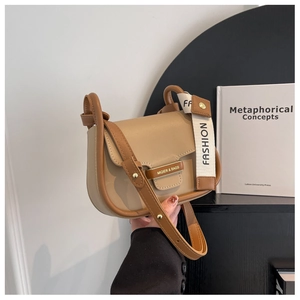 Detail of a beige leather crossbody bag featuring hardware buckle and fashion wide strap