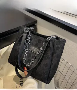 Détail du sac cabas en jacquard noir avec motifs floraux et chaîne en métal prune