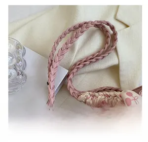 Detail of pink tote bag showing woven handles and decorative scarf with fruit pattern