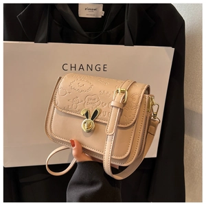 Detail of embossed PU leather crossbody bag with golden bunny lock and cute patterns