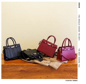 Four elegant women's leather handbags in black, burgundy and purple with gold hardware