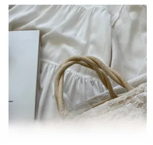 Detail showing soft woven rope handles and delicate lace trim with heart accents