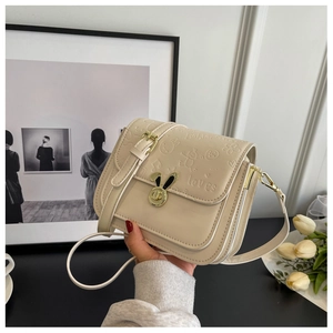 Detail of off-white crossbody bag featuring a bunny-shaped lock and cartoon embossing