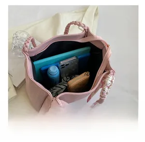 Detailed internal capacity of pink woven tote bag showing tablet, phone, and essentials