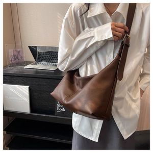 Lifestyle shot of large caramel leather hobo bag with wide strap for office wear