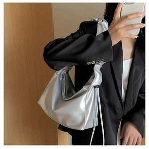 Silver metallic baguette hobo bag with knotted strap detail styled with black blazer