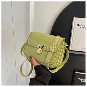 Detail of mint green crossbody bag with golden bunny lock and Love Songs embossed pattern