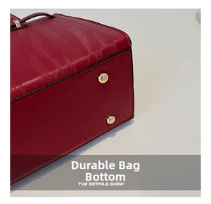 Close-up of wear-resistant burgundy textured leather bag bottom with golden metal feet