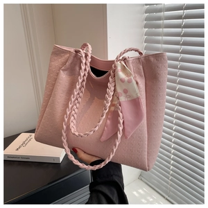 Detail of pink tote bag with woven handles and cherry pattern silk scarf decoration
