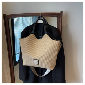 Détail du sac cabas tissé avec garniture en cuir noir et logo SouKu sur la texture