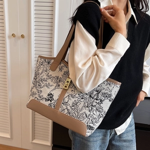 Cream canvas tote bag with floral patterns, leather handles and golden twist lock