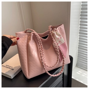 Detail of pink tote bag with star embossed texture and cherry print silk scarf