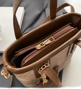 Detail of gold metal zipper on brown leather and canvas bucket bag close-up