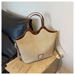 Détail du sac cabas tissé main avec finitions en cuir brun et sangle amovible