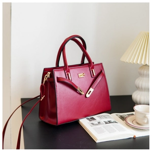 Dark red leather handbag on desk with modern home decor accessories and magazine