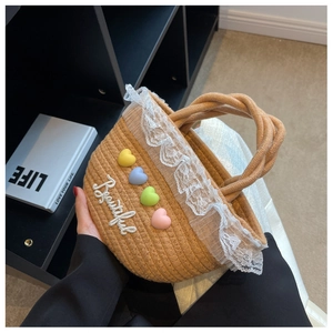 Detail of woven straw handbag featuring lace trim, colorful hearts, and Beautiful embroidery