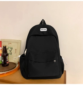 Detail view of black waterproof nylon backpack with BOKA BAG logo and silver D-ring charm