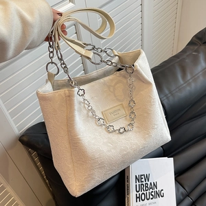 Sac fourre-tout beige minimaliste avec texture florale en relief et chaîne en métal argenté