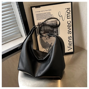 Detail of black pebbled leather hobo bag with gold adjustable buckle and wide shoulder strap