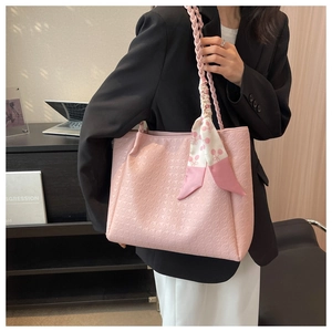 Detailed view of pink tote bag featuring houndstooth texture and stylish scarf decoration
