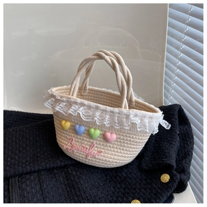 Detail of cream woven handbag with pink Beautiful embroidery and lace trim