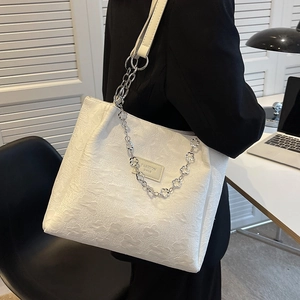 Grand sac cabas blanc avec motifs floraux en relief et bandoulière chaîne élégante