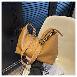 Detail of caramel lychee grain leather bag with adjustable golden buckle and metal zipper