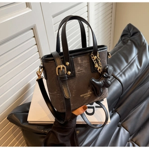 Detail of dark grey vintage mini bucket bag with gold hardware and animal charm