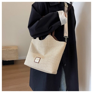 Détail de ce sac fourre-tout en paille tressée avec bordure en cuir marron et logo
