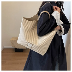 Détail du grand sac cabas tissé à rayures avec étiquette en cuir et bandoulières