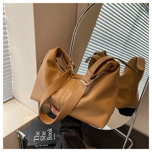 Detail of caramel leather hobo bag with pebble texture and adjustable shoulder strap