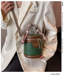 Detail einer grünen Vintage-Beuteltasche aus Leder mit Seidentuch und Goldteilen