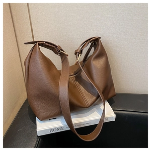 Detail of dark brown lychee pattern tote bag with adjustable strap and gold hardware