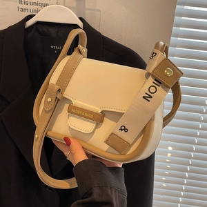 Minimalist cream and brown saddle crossbody bag with dual straps and gold metal plate