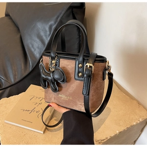 Detail of vintage brown tote bag with black trim and cute puppy charm accessory