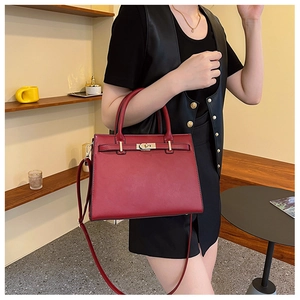 Detail of red bridal handbag featuring golden hardware and adjustable leather strap