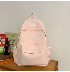 Close-up of pink backpack showing BOKA BAG logo patch and front pocket details