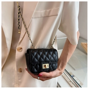 Detail of black quilted leather crossbody bag featuring gold chain and turn-lock closure