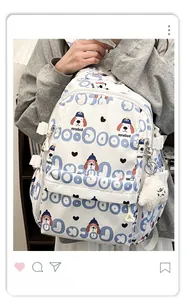 Vue détaillée du sac à dos blanc avec imprimés bleus et porte-clé en peluche mignon