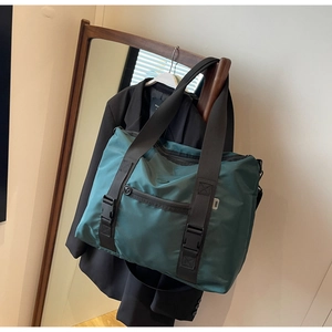 Détail du sac fourre-tout en nylon imperméable vert foncé avec sangles et boucle