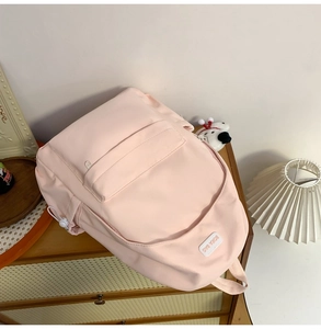 Close-up of pink nylon backpack with BOKA BAG logo and side drawstring pockets