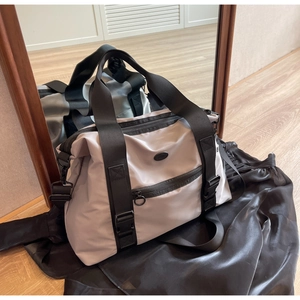 Détail du grand sac de voyage en nylon avec sangles noires et poche zippée renforcée