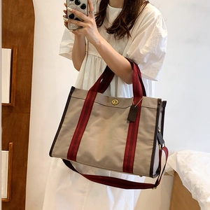 Minimalist canvas tote bag with striped handles and crossbody strap for daily commute