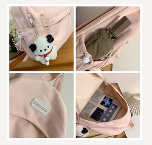 Pink nylon backpack detail showing side pockets, internal compartments and cartoon charm