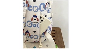 Détail de la poche latérale d'un sac à dos blanc à motif de chien tenant un smartphone
