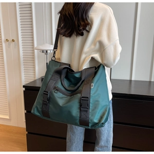 Détail du sac de voyage en nylon vert foncé avec tissu imperméable et boucles robustes