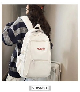 Detail view of white minimalist backpack featuring Ruikeda red embroidered logo