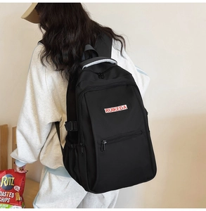 Detail view of large capacity black nylon backpack showing side buckles and zippers