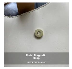 Detailed macro view of high-quality white leather and textured golden magnetic buckle closure