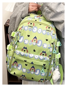 Détail du sac à dos vert clair avec motifs de chien cartoon et pompon décoratif